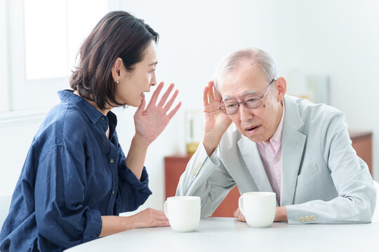 難聴の高齢者に大声で話をする女性