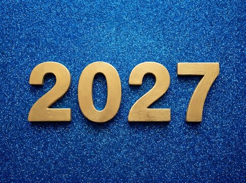 Golden numbers 2027 on a sparkly blue background represent new year celebration and future planning.