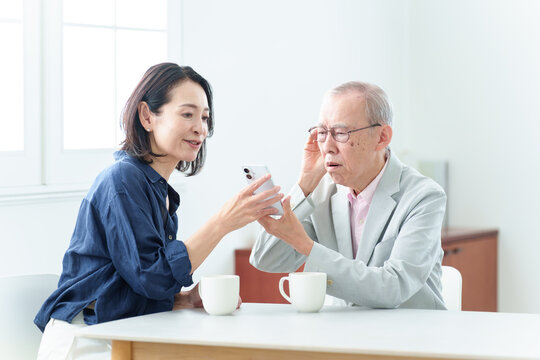 スマートフォンの説明を受ける難聴の高齢者人物,