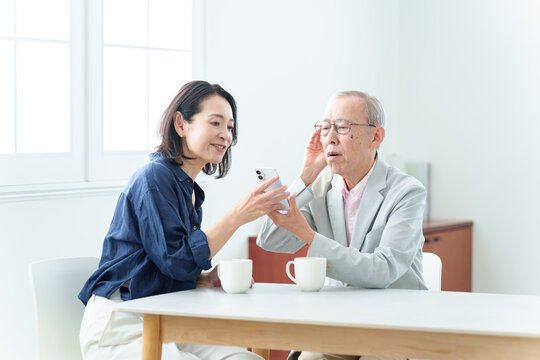 スマートフォンの説明を受ける難聴の高齢者人物,