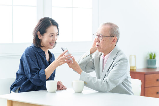 スマートフォンの説明を受ける難聴の高齢者人物,