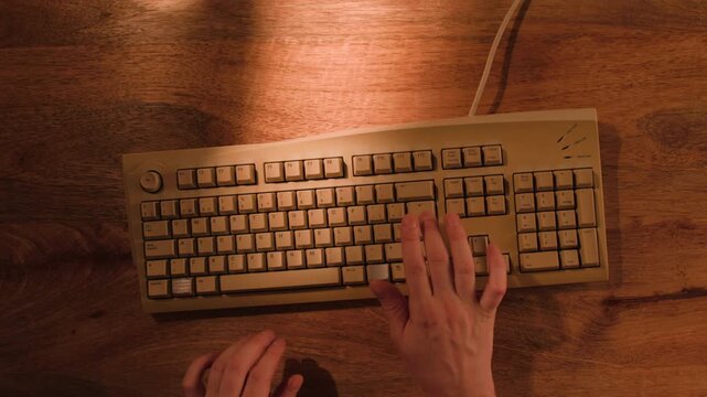 Man working and gaming on retro computer PC, IT engineer with vintage computer at home, using old fashion technology, close up of retro setup. 