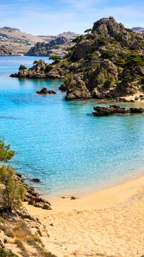 Idyllic Beach Scene at Mikri Vigla: Captivating Sandy Shoreline Merging with Turquoise Waters and Surrounding Rocky Outcrops on a Bright Sunny Day in the Cyclades