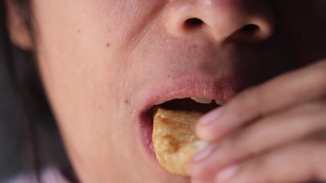 woman eat Pancong cake,  is traditional Indonesian snack made from rice flour mixture mixed with vanilla and coconut milk plus salf and sugar to taste