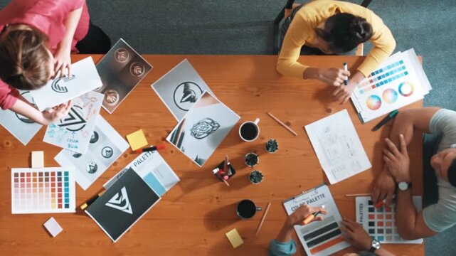 Top view of manager writing idea on sticky notes and explain idea about web design. Professional marketing team or programmer brainstorming idea while looking at tablet with color palette. Symposium.