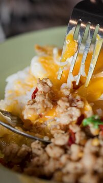 Eating Thai Pad Krapow Minced Pork with Fried Egg and Rice