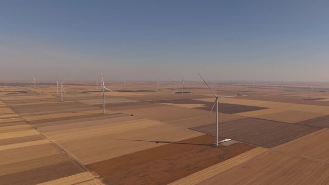 Wind Turbines Scattered Across Brown and Gold Agricultural Plots