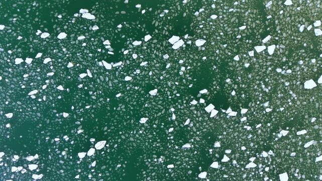 Aerial top-down drone shot of broken ice floes on the frozen Baltic Sea at the Bay of Gdańsk, Poland, an icy winter texture