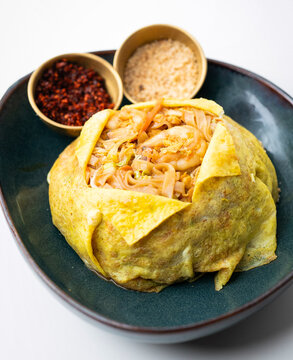 Stir-fried noodles, Traditional Thai pad, Thai wrapped in egg with big shrimps, Thai stir-fried noodles with shrimps and egg wrap, Thai food style, Thai street food, Pad Thai with Egg Wrap