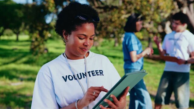 Volunteer, tablet or happy woman in park for outdoor charity, contribution or community service. Female person, activist or NGO group with technology or app for social responsibility or team outreach