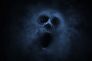 Naklejka premium Screaming ghost face on black background with smoke mist fog, Halloween theme