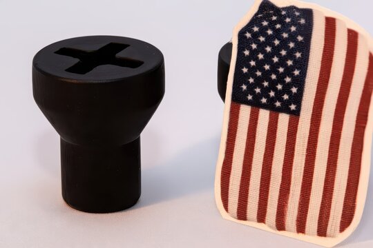 Black object with cross slot and US flag patch