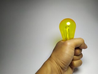Hand holding yellow light bulb representing idea concept and innovation © shalahuddin