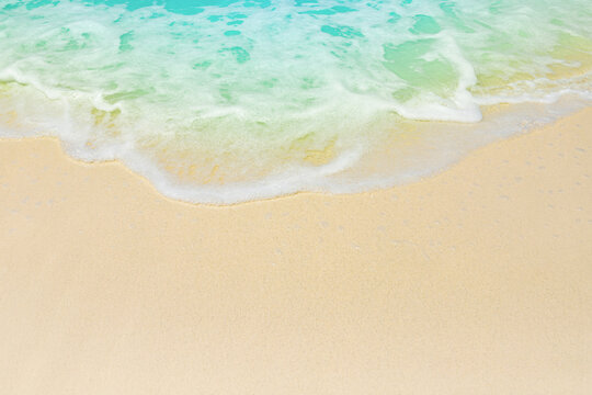 soft foam of turquoise wave on sandy beach, seascape as background