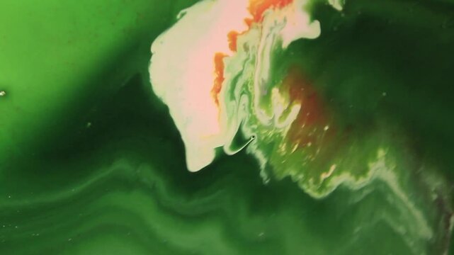 keindahan dan ketenangan proses pencampuran cairan warna (fluid art) yang menampilkan gradasi warna hijau yang menenangkan, dipadukan dengan sentuhan putih dan oranye yang artistik