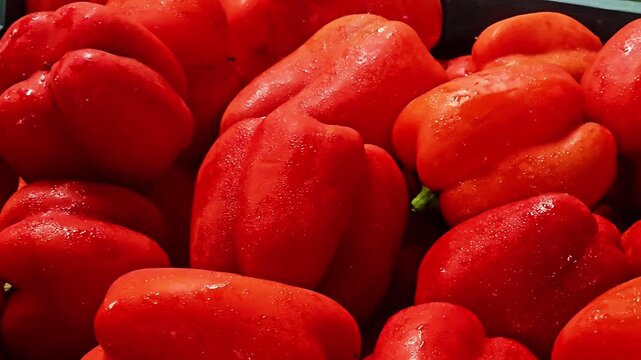 Close-up of fresh red bell peppers displaying bright skin, crisp texture, and vibrant color, perfect for healthy food and cooking concepts. 