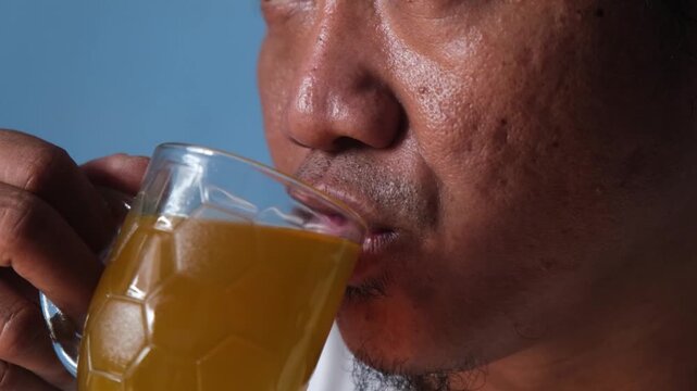 Close up of asian man drinkig hot herbal tea during sick days at home