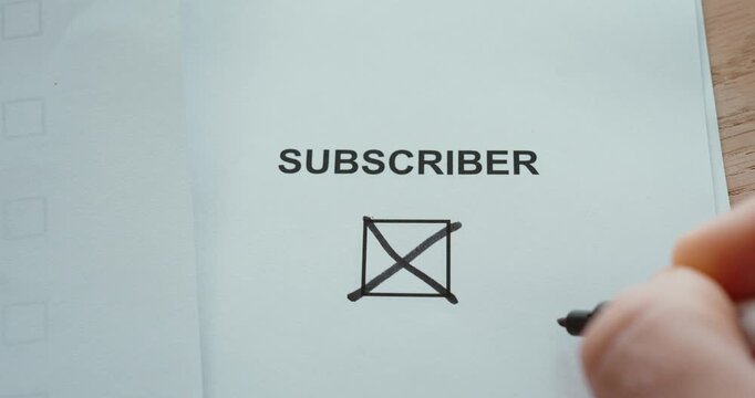 Hand checking a Subscriber checkbox on paper, representing online subscriptions and digital content.