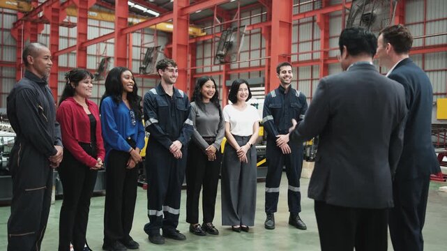 Group of industry multiracial workers team standing together, listening to business manager's speech, meeting and brainstorming, union cooperation in manufacturing factory, professional occupation.