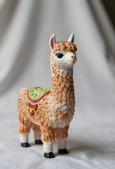 Fototapeta premium Childhood play and imagination, cute llama figurine with saddle for nursery decor and creative storytelling in a playful home environment setting