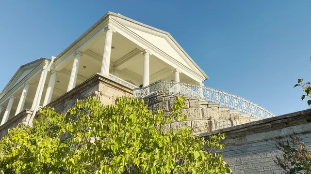 POV walkthrough of empty Catherine Park, Pushkin, Saint Petersburg shot on stabilizer. Smooth camera motion reveals majestic columns, evoking quiet awe and serene wonder.