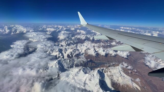 Airplane Wing over Snow-Capped Hindu Kush Mountains in Afghanistan