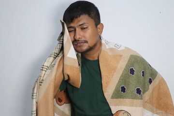 Sick man wrapped in warm blanket wiping sweat with fabric indoor © hattaarshavin