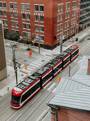Fototapeta premium High angle view of a red streetcar on city streets of Toronto