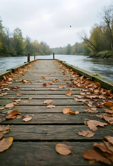 Fototapeta premium Solitude and mindfulness, wooden pier covered in autumn leaves extending into a calm river during a peaceful fall season with overcast sky