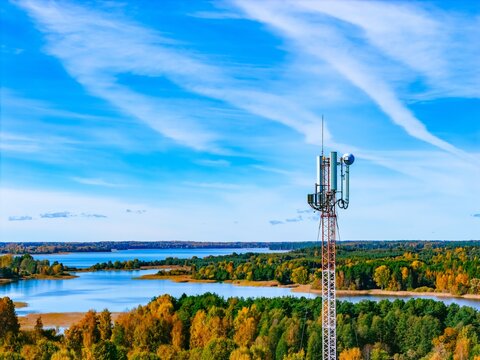 Drone aerial view of 5G 6G cellular telecommunication tower over autumn lake network signal