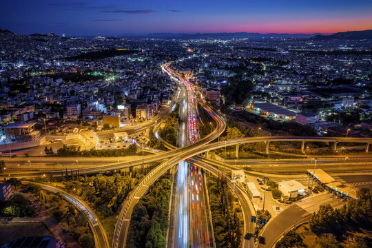 Aerial view of the illuminated skyline of Athens, Greece, with the national highway leading into the urban city at a big road junction<