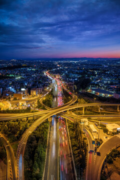Aerial view of the illuminated skyline of Athens, Greece, with the national highway leading into the urban city at a big road junction