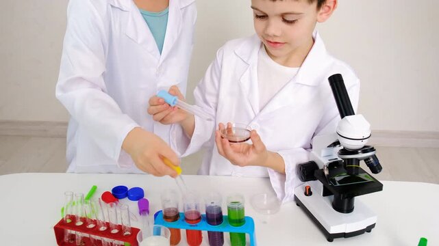 Laboratory examination of a child with test tubes, reagents and a microscope. Selective focus.