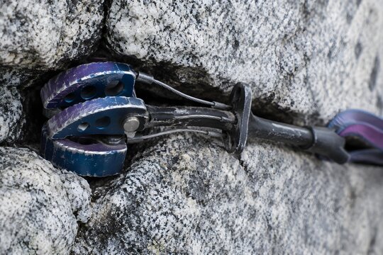 Cam lobes jammed in a granite crack with scuffed anodised faces and bent wires