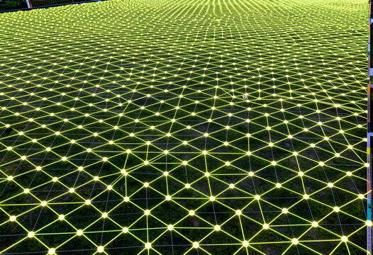Connectivity and digital network, glowing yellow nodes and lines forming a geometric mesh pattern over grass for technology and communication infrastructure