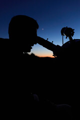 Fototapeta premium Amateur astronomer observing stars, planets, Moon and other celestial objects with a telescope in nature.