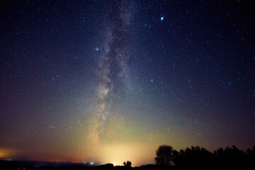 Fototapeta premium Summer Milky Way stars and landscape scenery silhouettes.