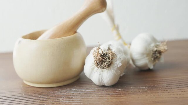 garlic mortar and pestle with fresh garlic cloves close up