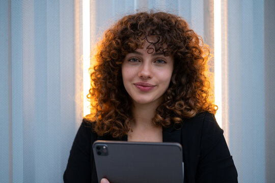 Young white woman holding tablet in indoor business setting