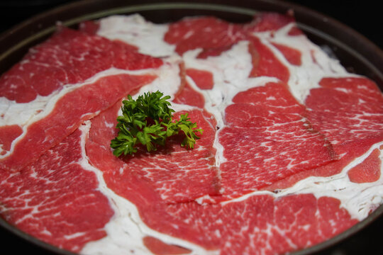 Fresh beaf thinly sliced on black dish for hot pot