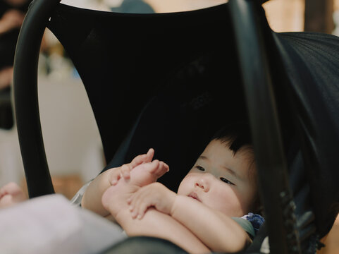 Close-up of an adorable baby sitting in a stroller on holiday in Spain