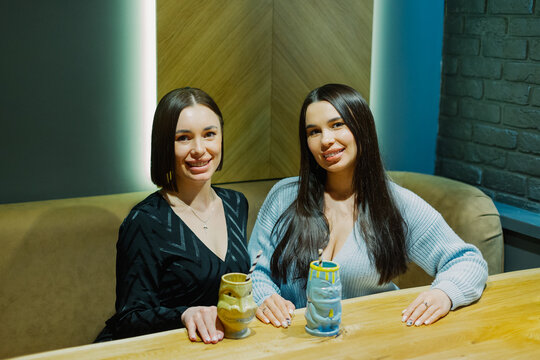 Two beautiful women are sitting at a table in a cafe