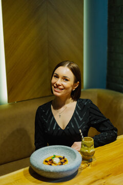Beautiful young woman sitting at a table in a cafe