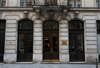 Obraz premium Urban architecture and historic building facade, classic european exterior with ornate stone carvings and dark wooden entrance doors on a city street
