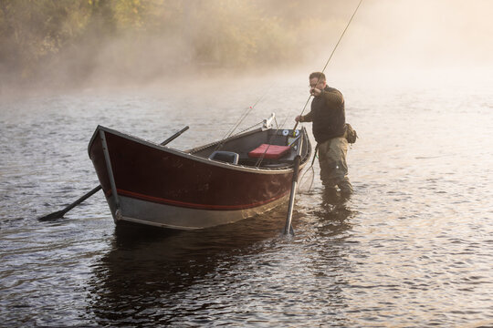 Fly fisherman unloads gear from drift boat