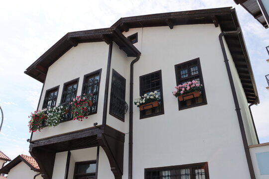 Close-up views of Konya houses restored a few years ago. Colorful flowers adorn the windows of these traditional Turkish houses. Konya, Turkey.