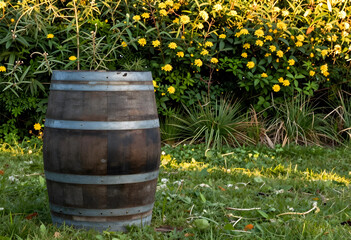 Naklejka premium Winemaking and rustic decor wooden barrel in a garden with yellow flowers for winery branding vineyard lifestyle and traditional craft production