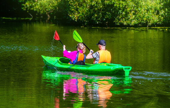 A man and a woman floating in a canoe on the river

