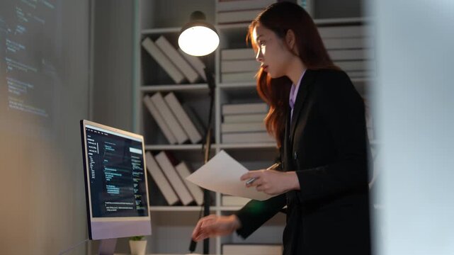 Asian programmer woman coding on computer at night