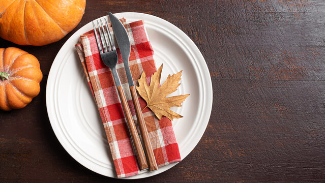 Autumn table setting with maple leaf on dark wooden background